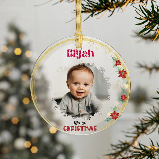 Round baby's first Christmas ornament with a photo and 'My 1st Christmas' text, hanging on a tree.