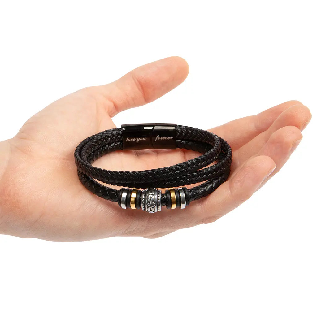 Black braided leather bracelet with metal beads on a hand against a white background